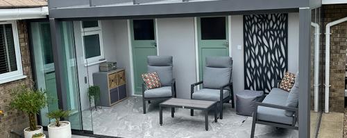 Domestic glass room with grey furniture.